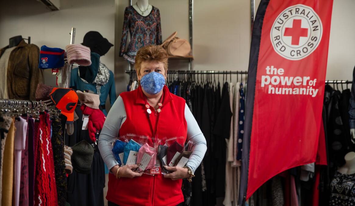 NEW FOCUS: Volunteer Trish Miller with some of the handmade masks at the Australian Red Cross store in The Levee. Picture: Marina Neil