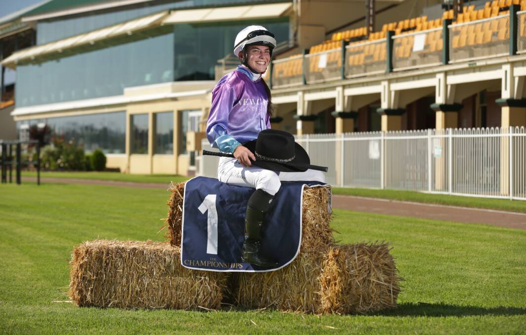 FUNDRAISER: Jockey Lexi McPherson sits on a bale of hay trackside at Newcastle Racecourse. Picture: Simone De Peak.