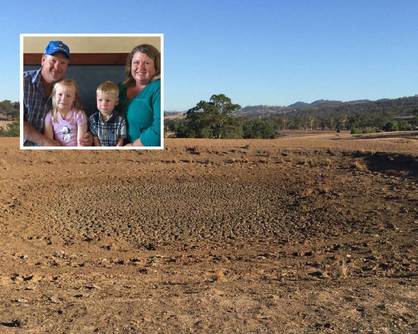 DROUGHT: Arty and Rachell Cox with their two children (insert) and a dry dam on their property at Owen's Gap, near Scone. They have been hand-feeding livestock since August last year.
