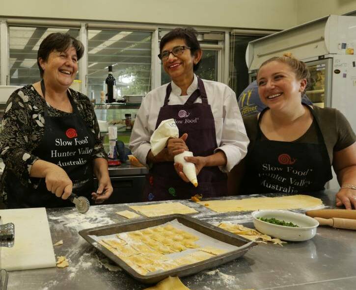 FOCUS: Chef and Slow Food Maitland Earth Market chairwoman Amorelle Dempster (centre) making a dish with volunteers in her cafe. 