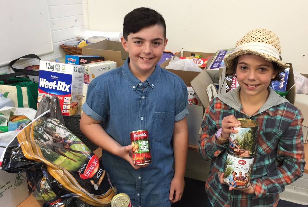 FOOD DRIVE: Tenambit Public School students Kane Cox and Aishnn Luliano with some of the items that have been donated. 
