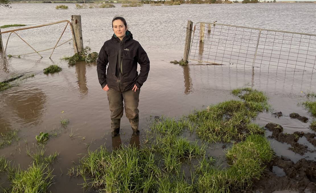 GUMBOOTS: Belinda-Jane Davis stands in front of submerged paddocks during the July flood. 