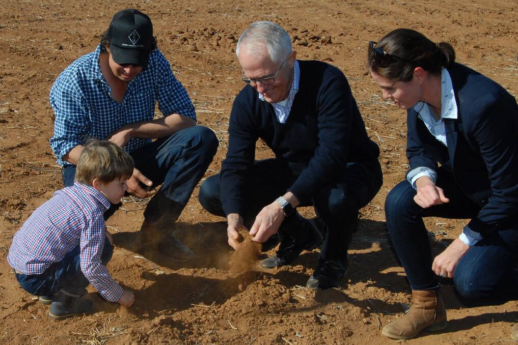 DRY: Prime Minister Malcolm Turnbull (centre) with farmer Phillip Miles (left), his wife Ashley and their son Jack (front) during a visit to Strathmore Farm in Trangie on Monday.