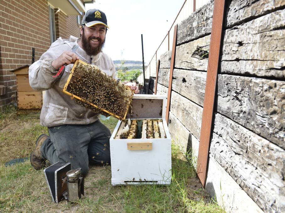 FOR THE LOVE OF BEES: Beekeeper Sam Giggins at his home in Raymond Terrace with some of his bees. Picture: Belinda-Jane Davis