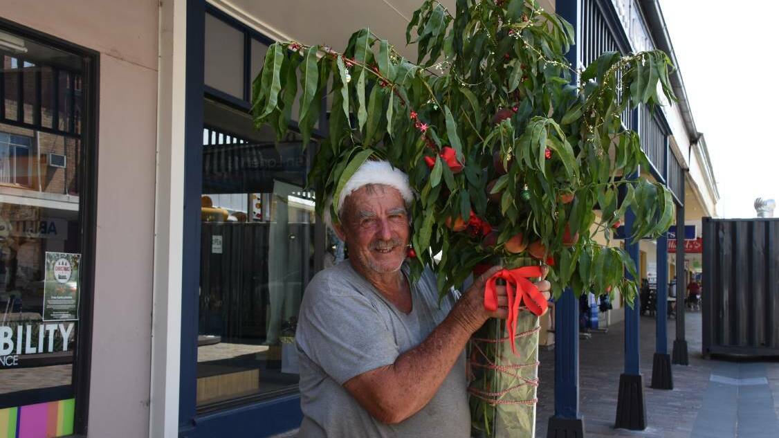 VOLUNTEER: Tony Millburn with peach branches to promote a peach rescue at the market in 2017.