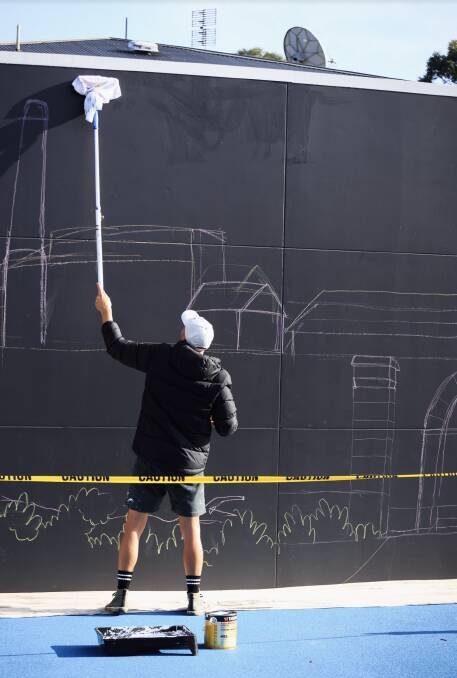 HISTORY IN THE MAKING: Newcastle artist Mitch "Revs" Resevsky works on a mural of the Hunter Valley at The Bradford Hotel in Rutherford. Picture: Sean Fox