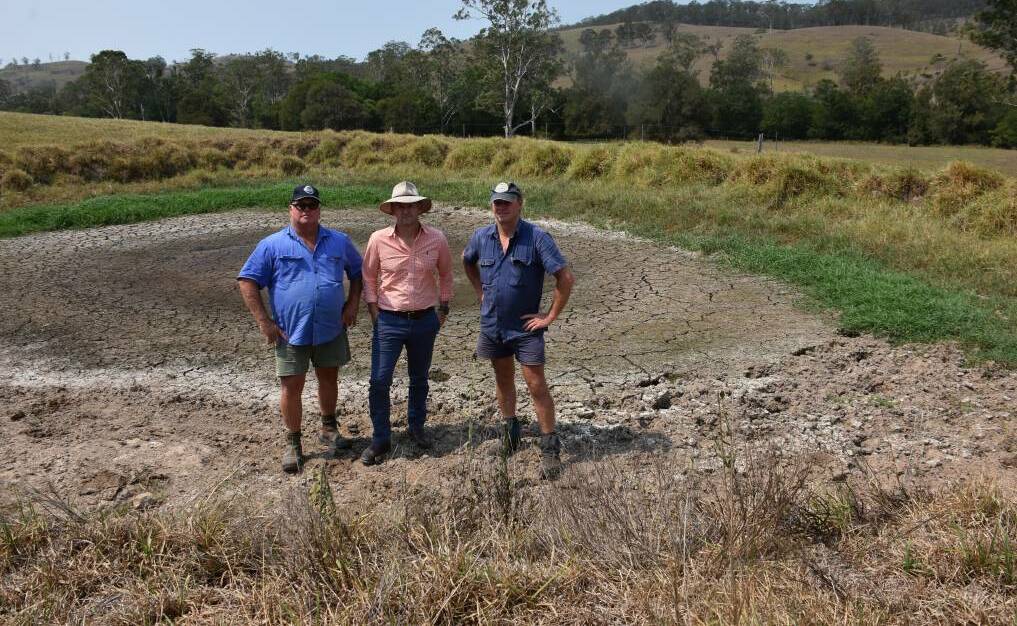HUNTER VISIT: Fourth-generation dairy farming cousins Bill Williams and Rod Williams with NSW Primary Industries and Water Resources Minister Niall Blair (centre) in a dry dam at Stroud.in February 2018. Picture: Belinda-Jane Davis