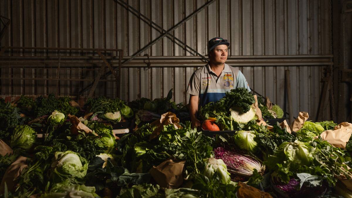 Farmer Liam Dennis at Nebo farm with some of the weekly vegetable boxes that are sold direct to shoppers. Picture by Marina Neil