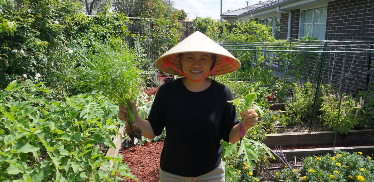 PERSISTENCE: Felicia Nguyen in her Asian suburban garden holding drought-affected produce. Picture: Belinda-Jane Davis
