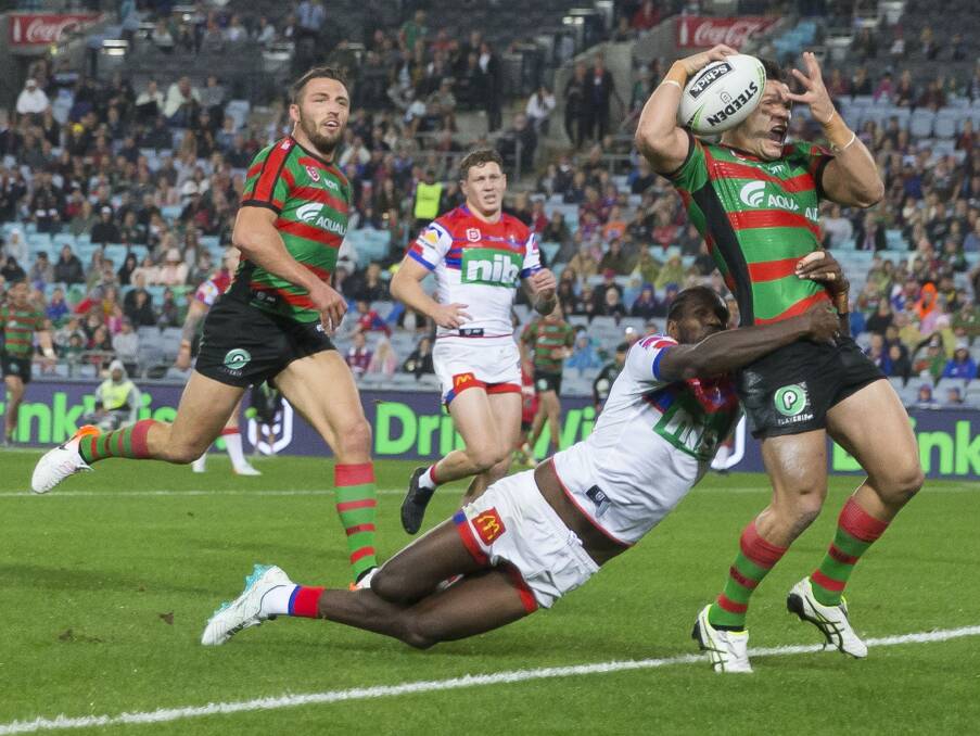JUGGLING ACT: South Sydney's James Roberts hangs onto the ball before scoring, despite Edrick Lee's tackle. Picture: AAP