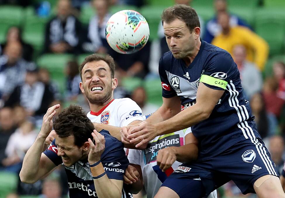 CRUNCH TIME: Melbourne's Leigh Broxham
and Robbie Kruse clash with Ben Kantarovski.
Picture: Getty Images