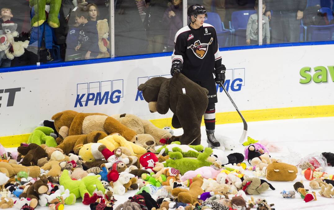RAINING BEARS: A Vancouver ice hockey player is surrounded by toys at the club's annual "Teddy Bear Toss" for charity. Picture: Getty Images