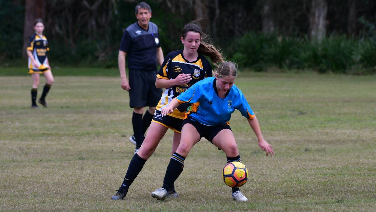 Abby Buttsworth (back) jostles for possession in MacKillop College's 3-2 defeat to All Saints College. Photo: Paul Jobber