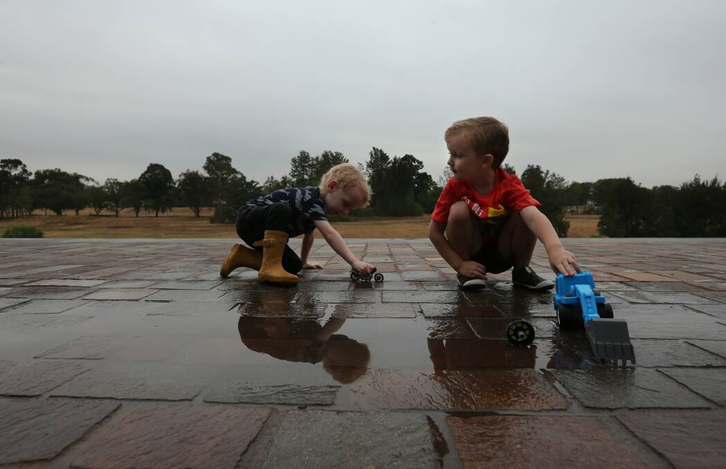 WELCOME SIGHT: Anakin Scoles, 3, of Maitland and Oli Taylor, 4, of Telarah playing in a puddle along The Levee after some rain on Thursday morning. Picture: Simone De Peak