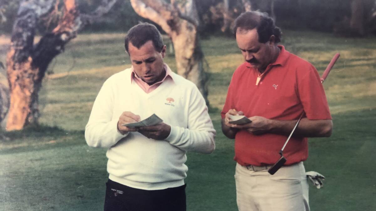 PRO-AM: The author signs his card with top professional Bob Shearer during a Pro-Am event in the 1980s.