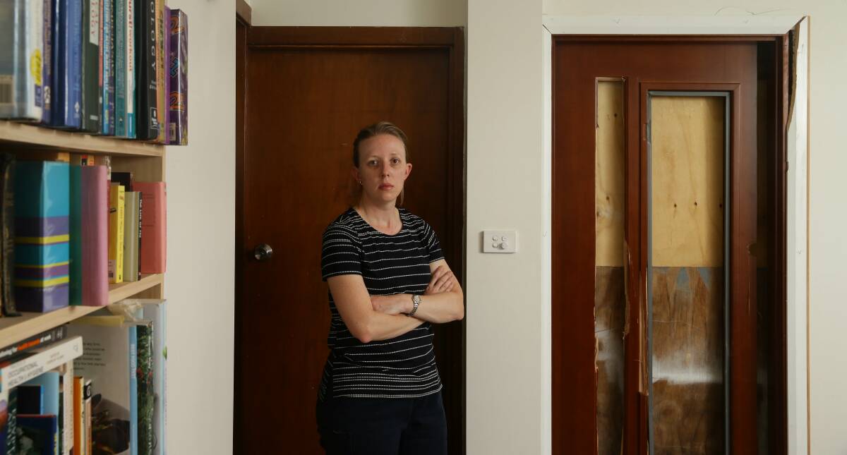 TERRIFIED: Julie Moore pictured inside her home with the door that was damaged during the invasion. PICTURE: Jonathan Carroll.
