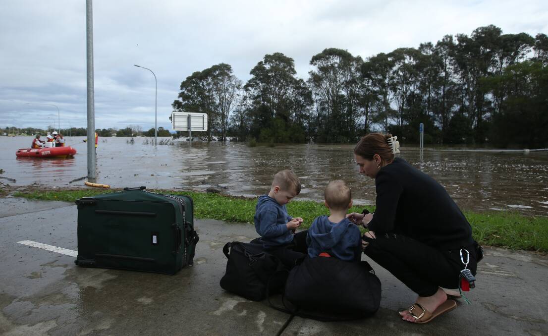 STRANDED: Alison Urch with her children after being evacuated by boat from Gillieston Heights where she was stranded overnight while visiting family. PICTURE: Simone De Peak