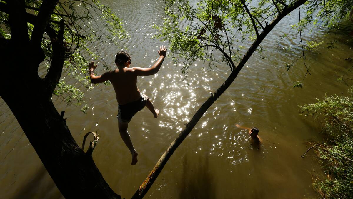Logan Watson and Lachlan Gruber pictured leaping into the Hunter River in January when temperatures were set to hit 40 degrees. Picture: Jonathan Carroll.