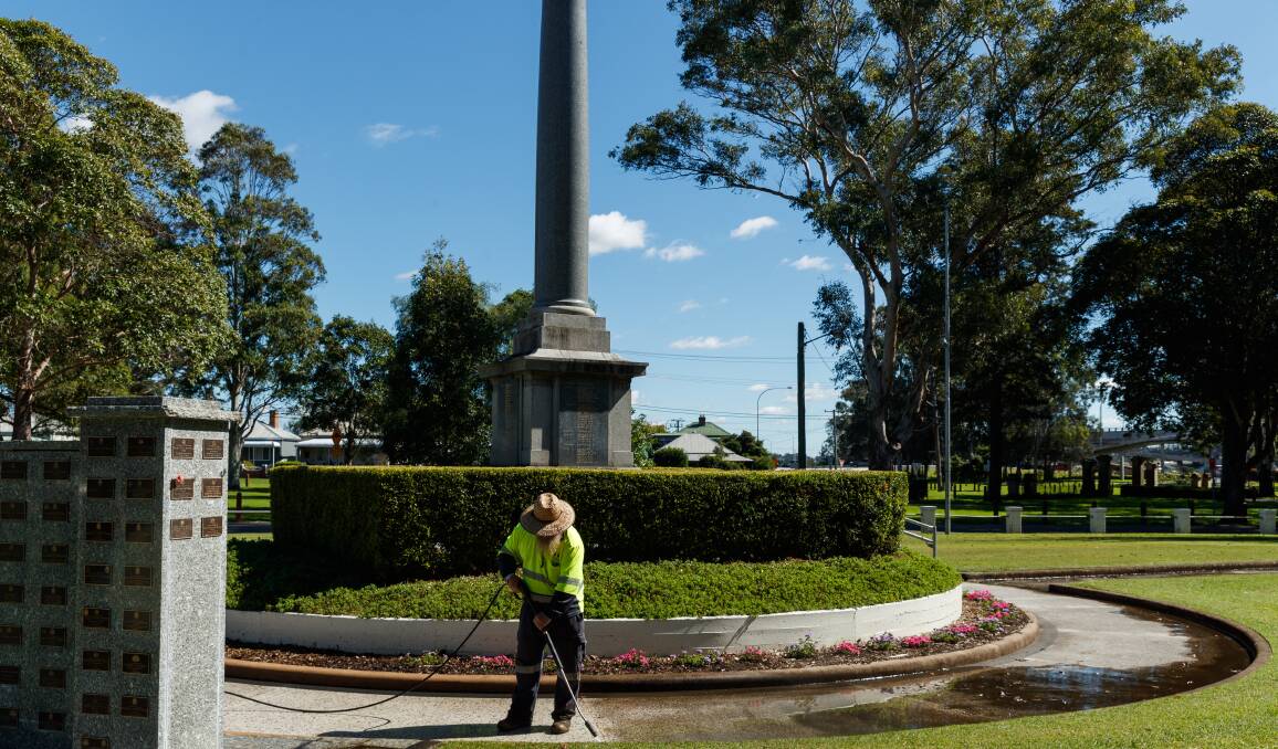 SPRUCE UP: Maitland City Council employee Mark Andrews cleans around the Maitland Park cenotaph in preparation for Anzac Day services. PICTURE: Max Mason Hubers.