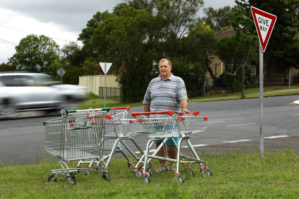 FERAL: Cr Henry Meskauskas on the median strip at Alexandra Avenue, Rutherford with abandoned trolleys. Picture: Jonathan Carroll.