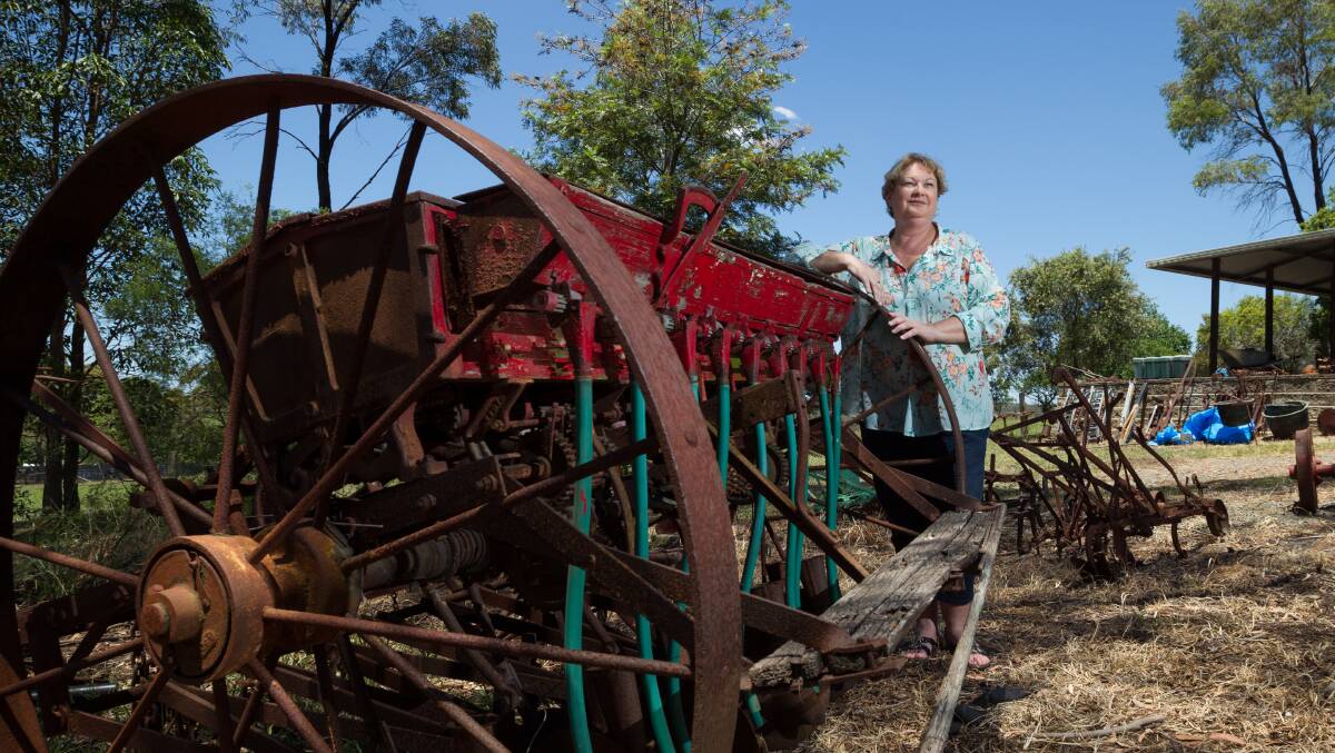 TREASURES: Daughter Jo Threlfo with some the farm machinery that will go under the hammer.
