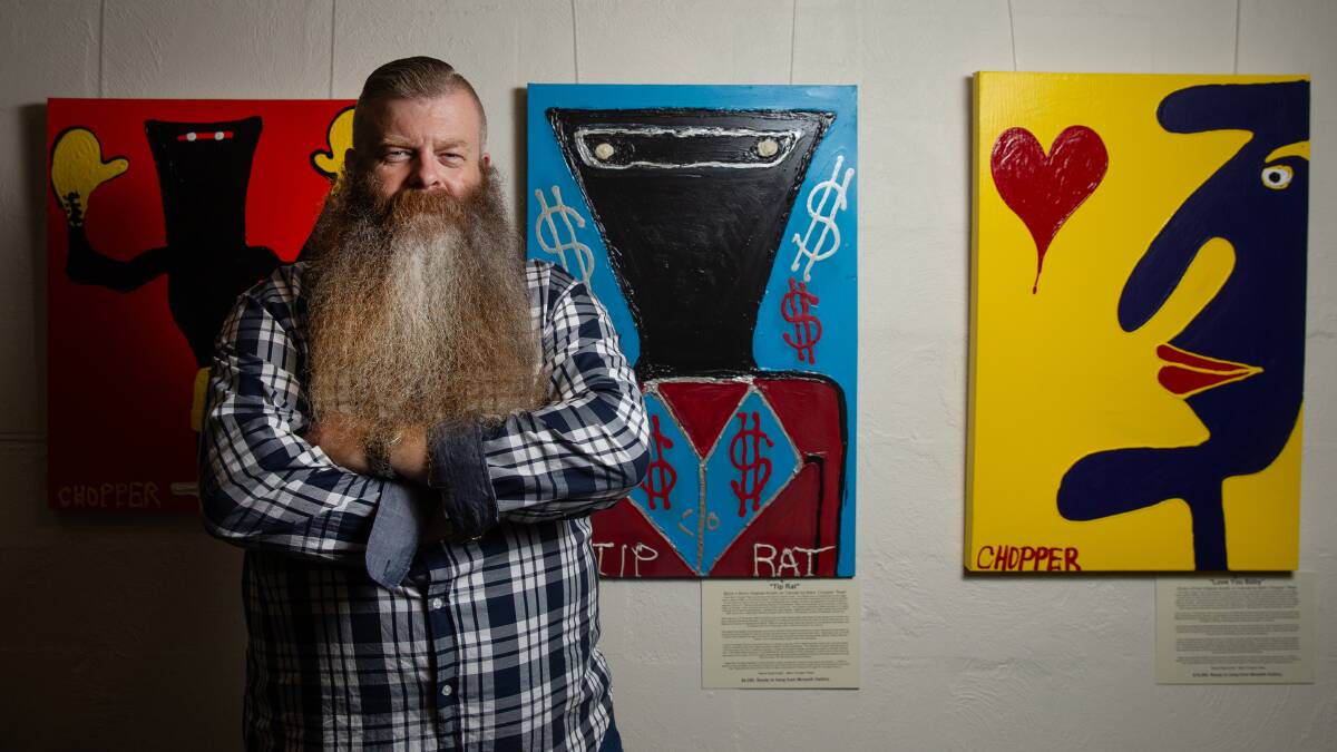 ROGUES GALLERY: Peter Hall pictured with some of Chopper Read's canvases. PICTURE: Marina Neil.