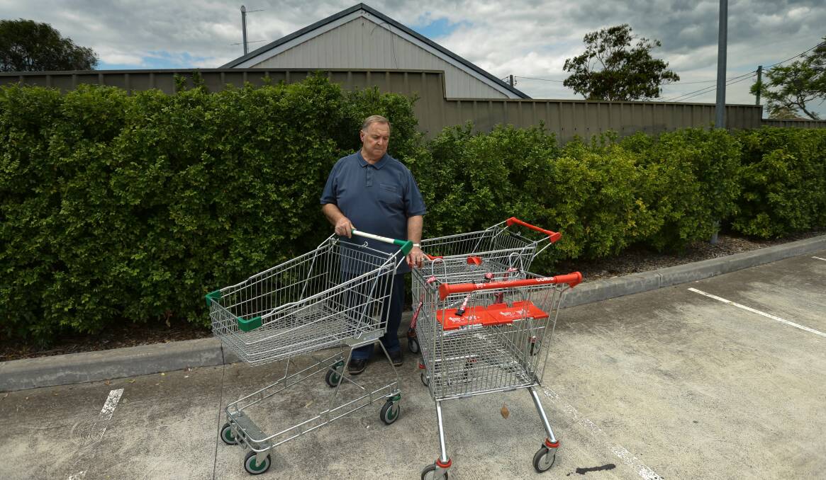 JUNKYARD: Cr Henry Meskauskas with feral shopping trolleys in the car park of Rutherford Community Centre yesterday. PICTURE: Jonathan Carroll.