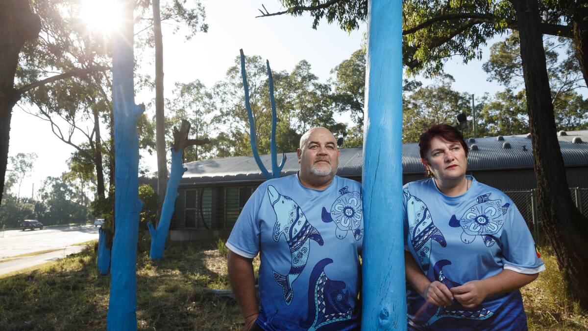 BLUE TRIBUTE: Danny and Jacqui Flaus and some of the trees they painted blue at East Maitland Fire and Rescue this week in memory of their son Brady. Picture Max Mason-Hubers. 