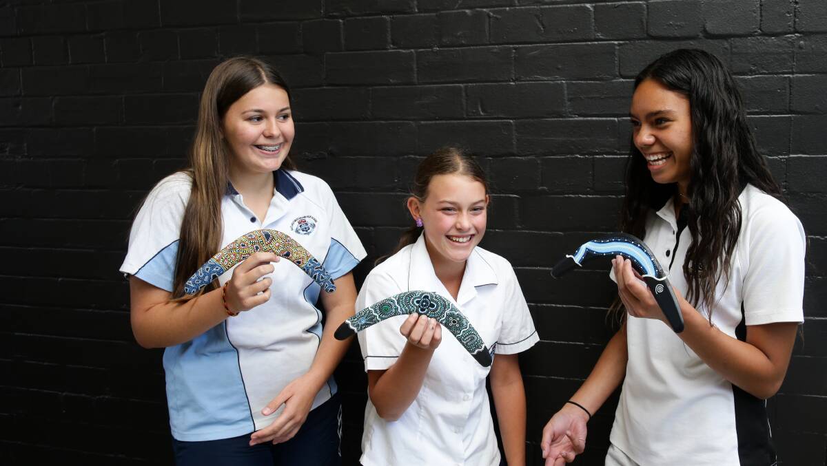 Maitland Grossmann High students Victoria Pearson, Zarah Williams and Natayah Wells with their boomerang artworks. Pictures: Jonathan Carroll.