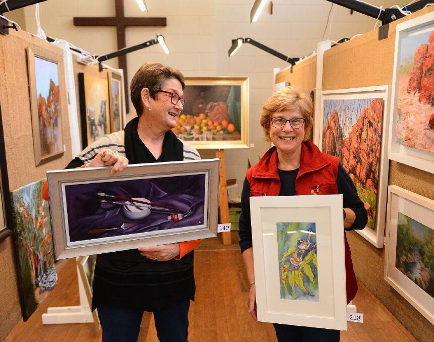 FRAME AND FORTUNE: Maitland Regional Society of Artists president Kay Sparkes and secretary Joanne Conder holding their works ahead of the exhibition.