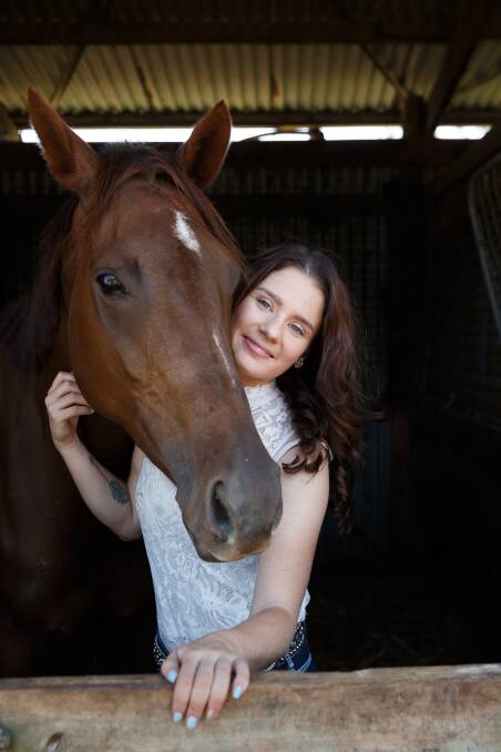STRONG BOND: Breanna Murrell, 24, and her chestnut thorougbred Neigh in a stable in Maitland. Picture: Max Mason-Hubers