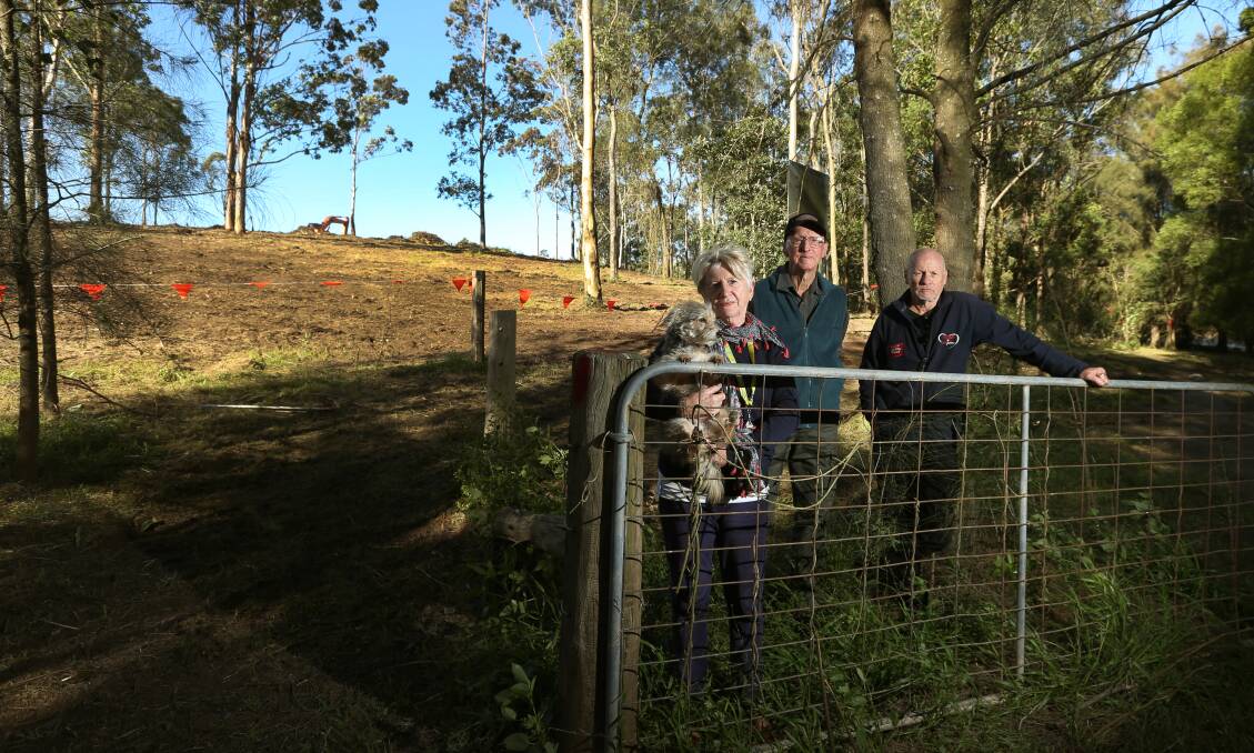 Clearing concerns: Locals Wendy Pearson with her dog Holly, Dave Harwood and John Brown in front of a cleared block. Photo: Marina Neil. 