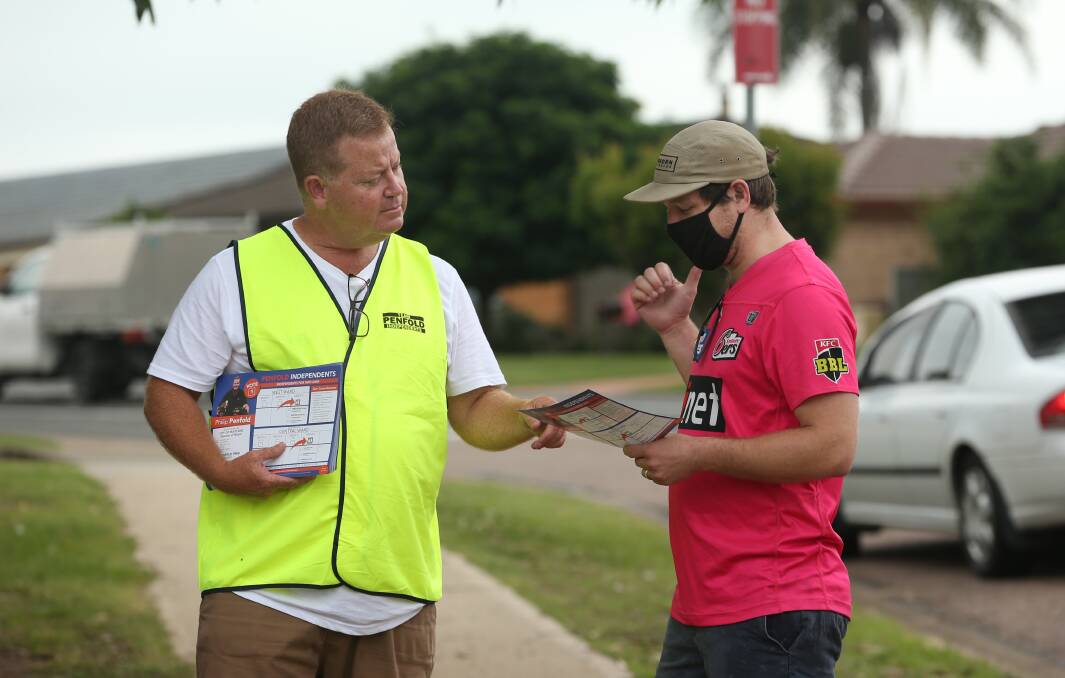 Philip Penfold handing out how-to-vote cards on election day. 