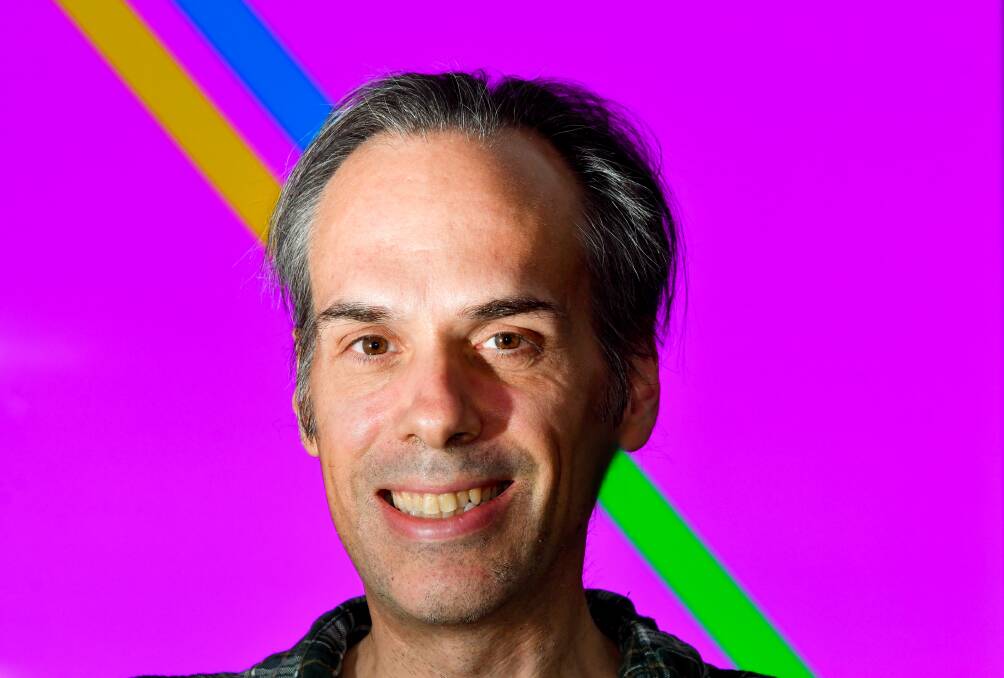 Scientist Philippe Chouinard's head obscures a line in a demonstration of the Poggendorff illusion. The green line connects to the blue line, but the illusion makes them appear disjointed. Picture: NONI HYETT