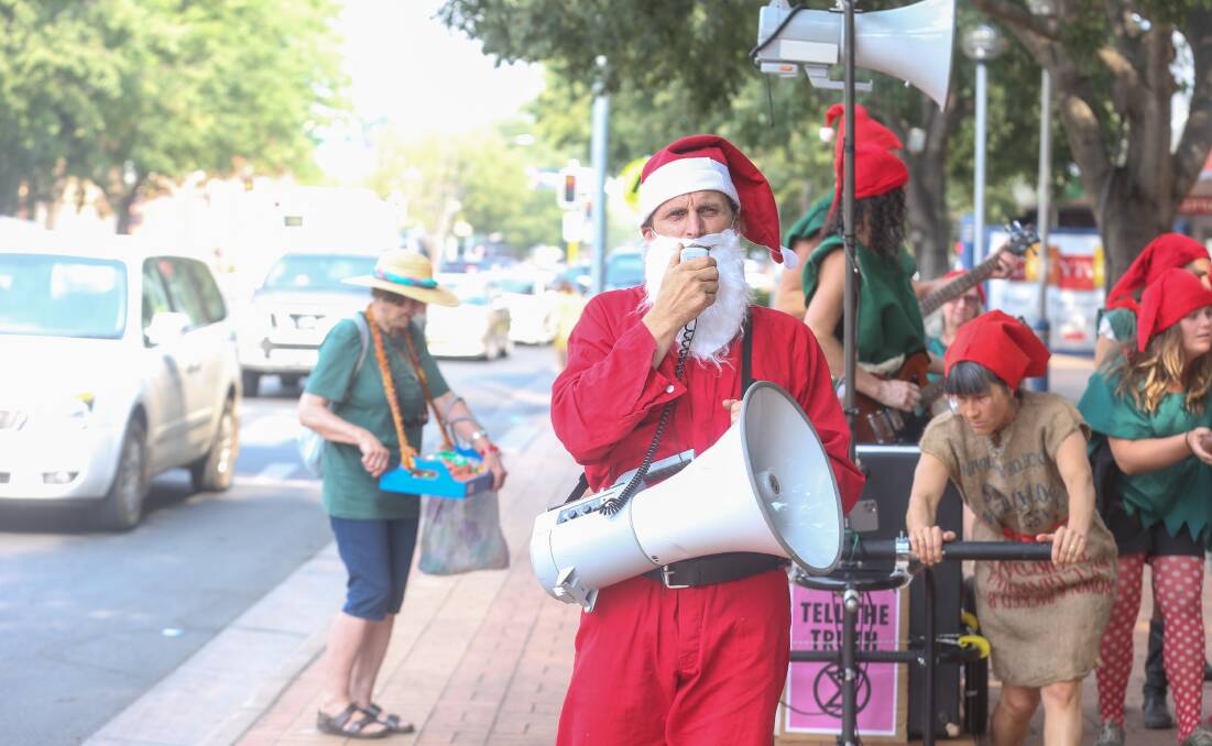 No sack just a megaphone: Santa delivers his concerns about climate change and its impact on his enterprise in Albury's Dean Street on Monday night. Picture: TARA TREWHELLA