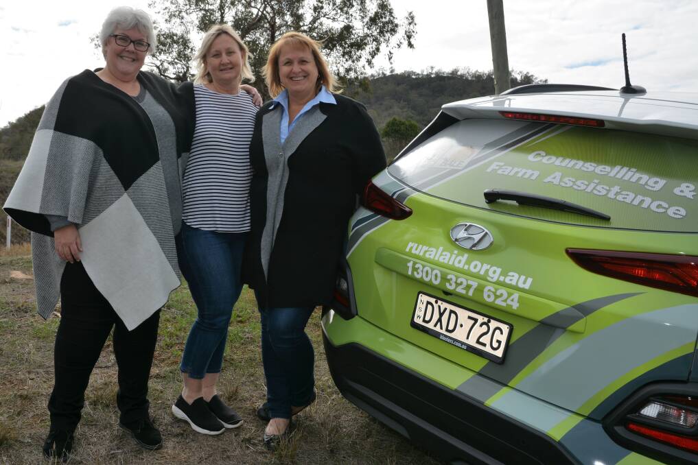 SUPPORT: Rural Aid counsellor Louise Gourley, Scone local Deborah Wharton and Rural Aid's Tracy Alder with one of the Rural Aid cars at a property near Scone on Tuesday.