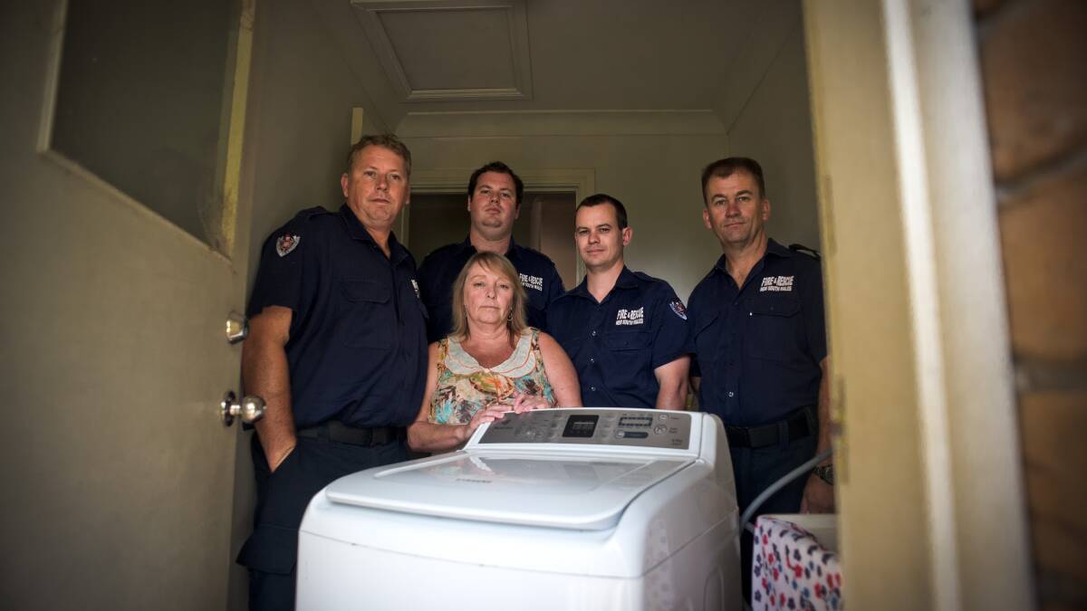 LUCKY: Gai Smith with firefighters Scott Armstrong, Nick Carrey, Dan Coutts and Station Officer Chris Holderberg with the washing machine. Picture: Perry Duffin