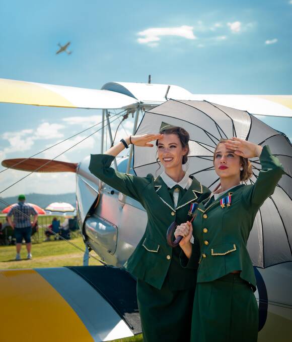 SKYWARD: Bianca Drain and Jasmine Bard scan the skies at the Hunter Valley Airshow on Sunday. The event featured rare planes, stunts and military aircraft. Picture: Perry Duffin