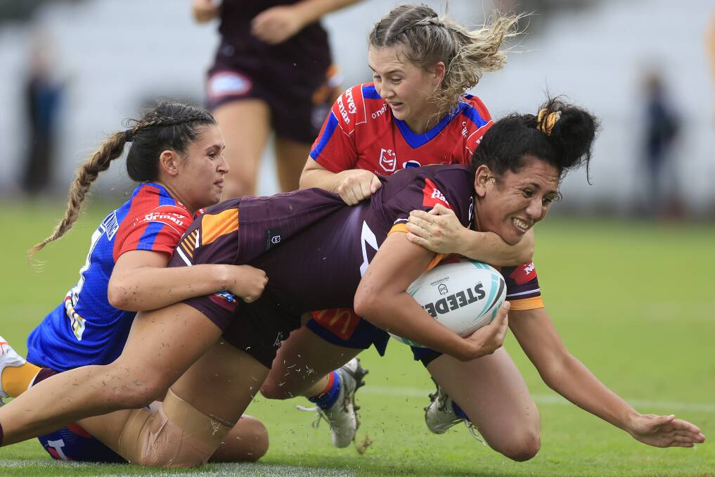 TOUGH DAY: Knights players take down Brisbane forward Kaitlyn Phillips at WIN Stadium. Picture: Getty Images 