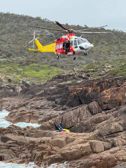 The Westpac Rescue Helicopter's critical care team had to be winched onto the rocks to treat the injured fishers who were able to make it back to shore. Picture by the Westpac Rescue Helicopter Service