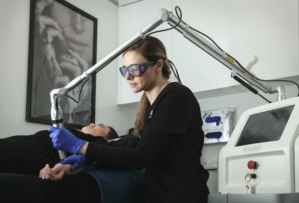CLEAN SLATE: Vamp dermal therapist Ginny Gruber Bucchi, uses a specialist laser machine to remove a tattoo from a client. Picture: Marina Neil.