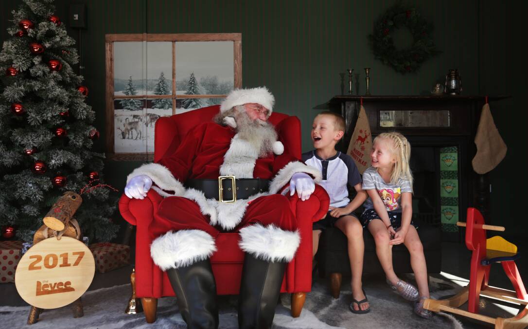 LEVEE LAUGHS: Santa having a Christmas photo with Noah Cant, 8, and Jazmyn Cant, 5, of Metford. Free photos will be available until December 23. Picture: Simone De Peak