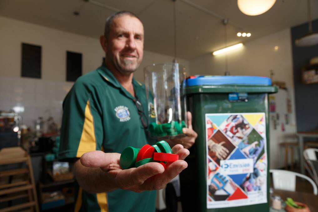 TOP IDEA: The Lorn Cafe's Craig Wyborn with some of the caps and a collection bin at the cafe. Picture: Max Mason-Hubers