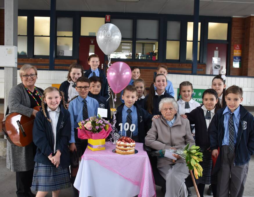 SURPRISE: Our Lady of Lourdes teacher Lisa Sansom and school students on Tuesday with their 100-year-old neighbour Marie Scarr on her birthday.