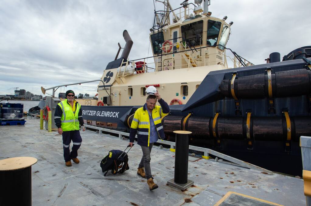 DRY LAND: Crew members Scott Henderson and Gerard Inkston depart the 'Svitzer Glenrock'. Pictures: Marina Neil