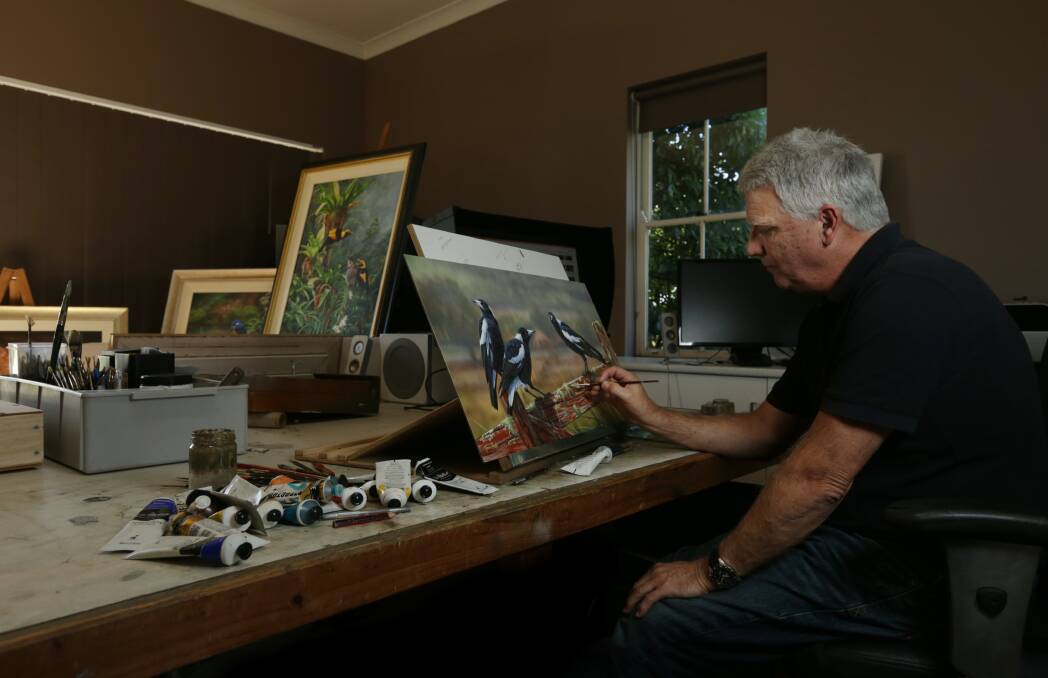 BIRD MAN: Wildlife artist James Hough working in his home studio, where he meticulously creates up to 100 paintings a year. Picture: Simone De Peak