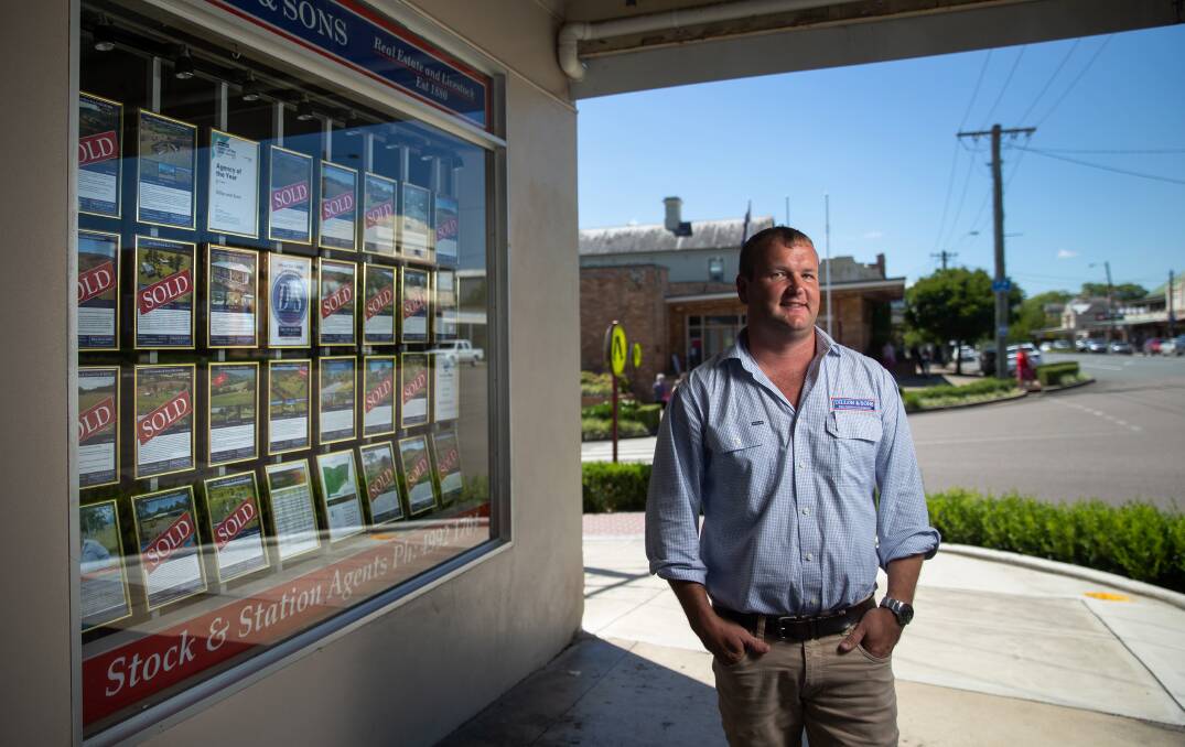 BOOMING: Dungog real estate agent Tavis Chivers, with a display window filled with "Sold" stickers. 