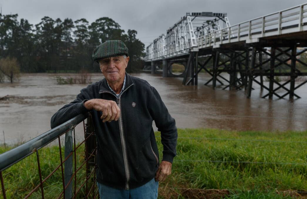 RIVER MAN: Farmer and author John Wright on his Phoenix Park property beside the swollen Hunter River, and with the Morpeth Bridge in the background. Pictures: Max Mason-Hubers 