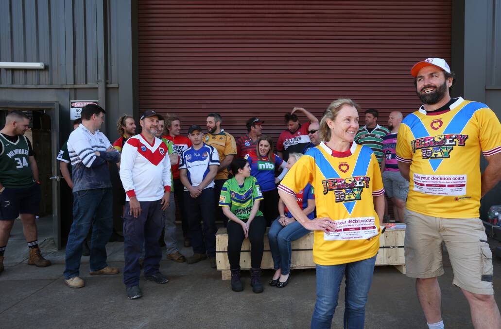 TEAM: The staff of Quarry Mining at Beresfield, with Managing Director Kari Armitage and colleague Peter Hodgson, wearing their jerseys to promote conversations about organ donation. Pictures: Simone De Peak