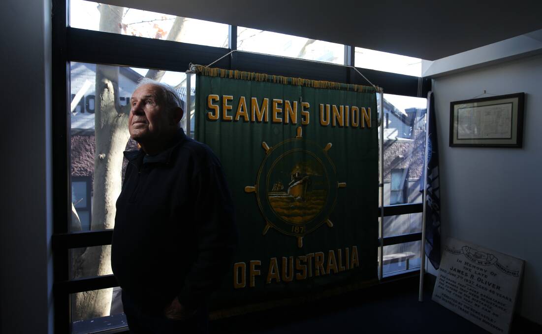 LIFE OF VOYAGING: Retired seafarer Tom Jones with an old union banner at the exhibition. 
